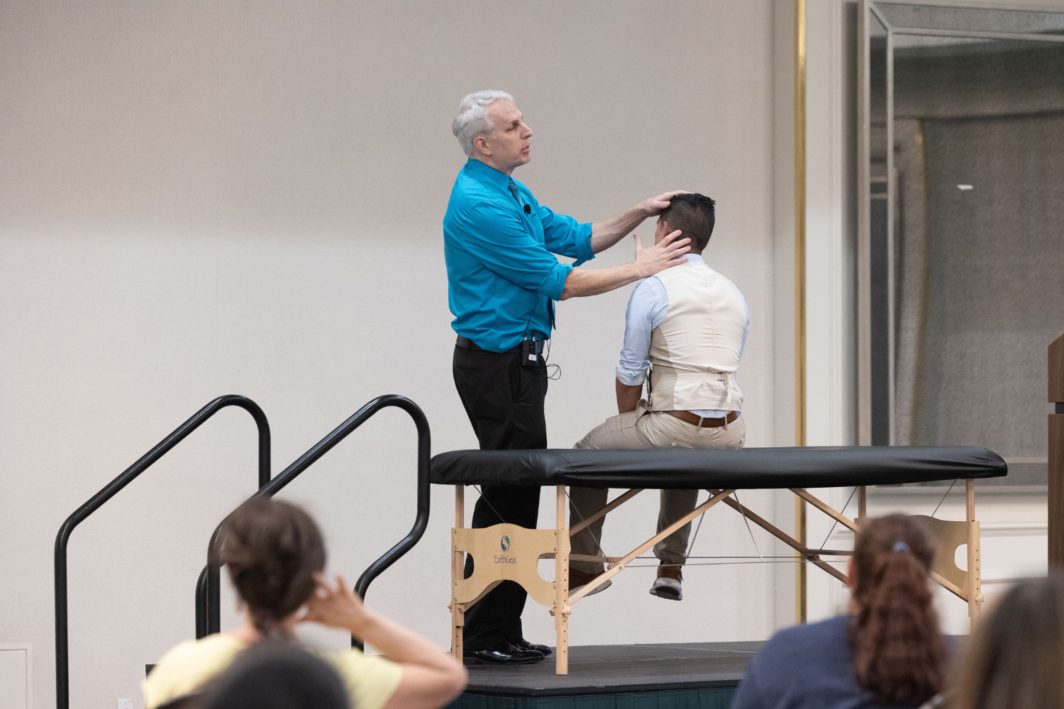 Doctor demonstrates OMT on a stage