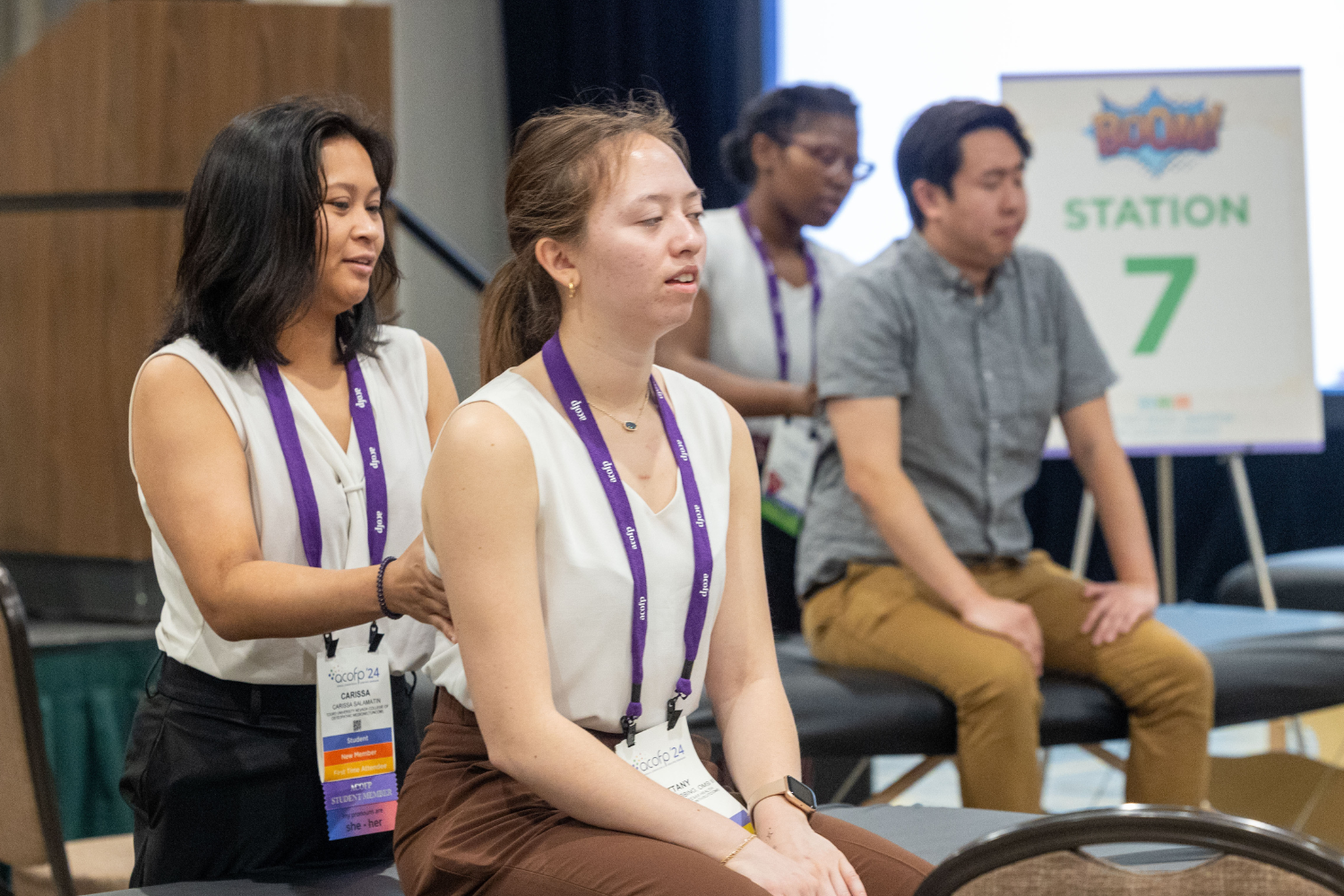 Woman demonstrates osteopathic manipulative therapy on person