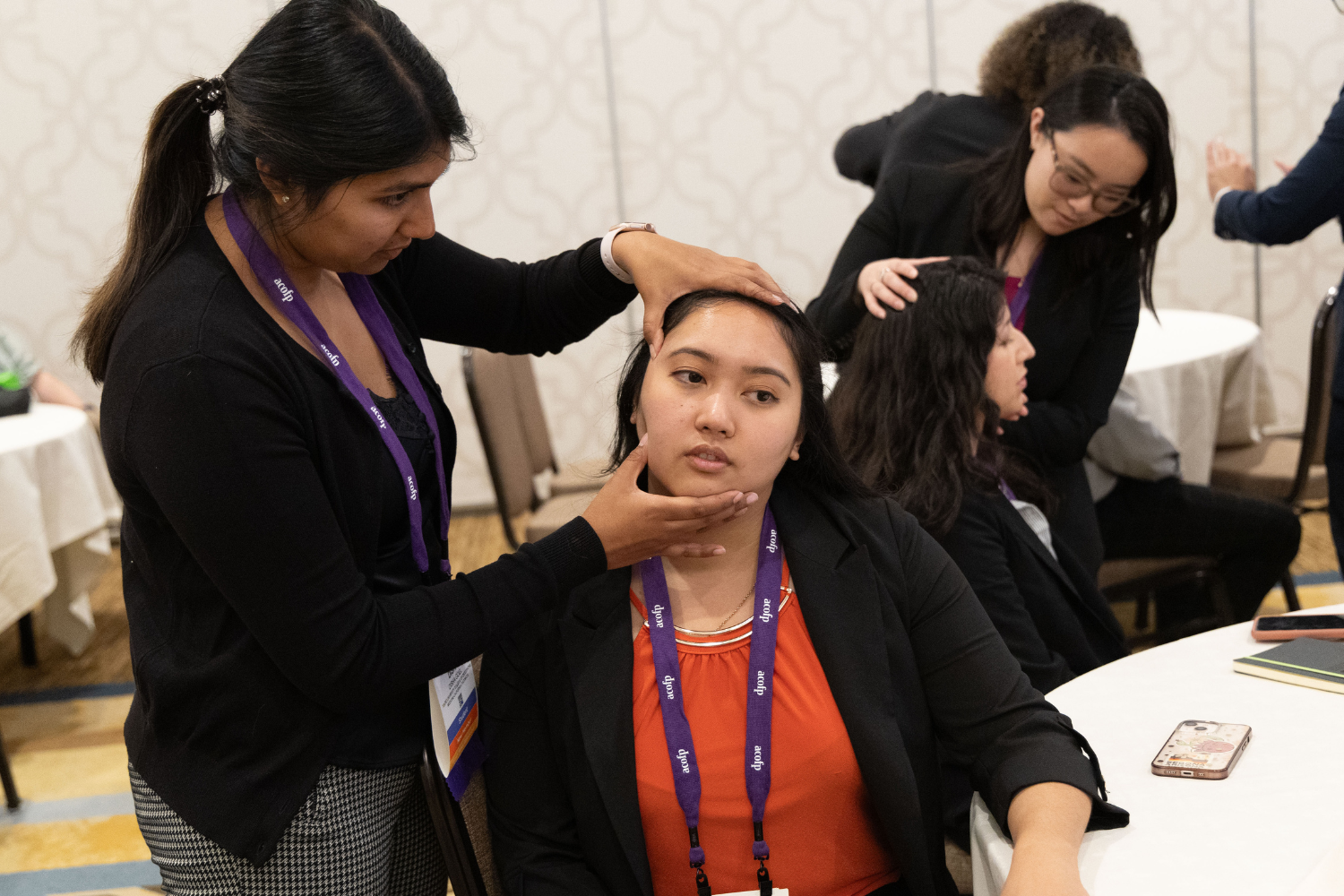 Woman demonstrates osteopathic manipulative therapy on person