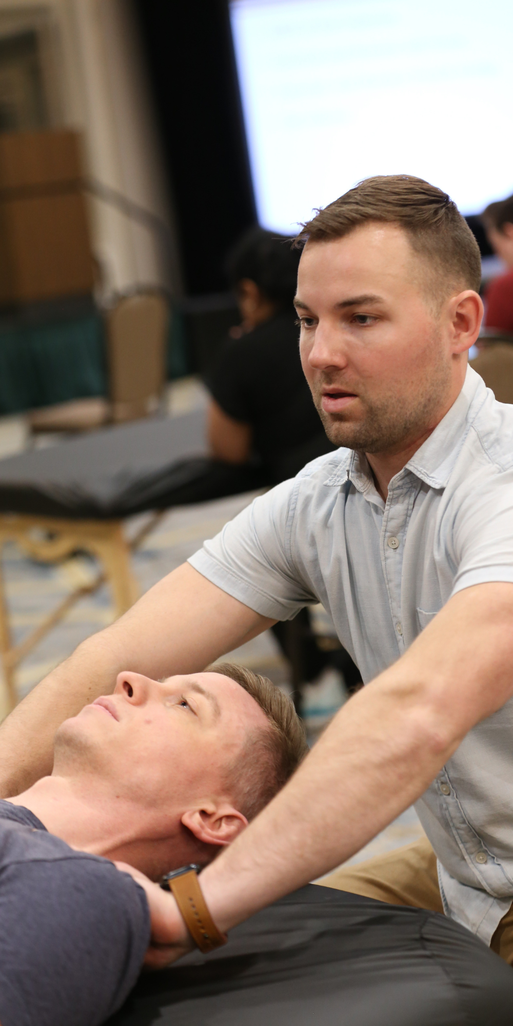 Man demonstrates osteopathic manipulative therapy on person