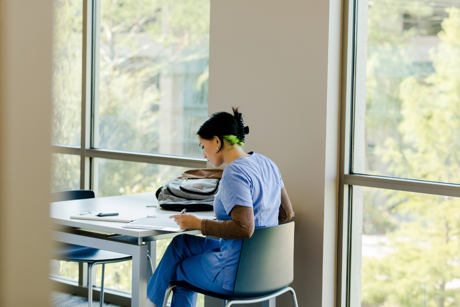 Woman in scrubs studying