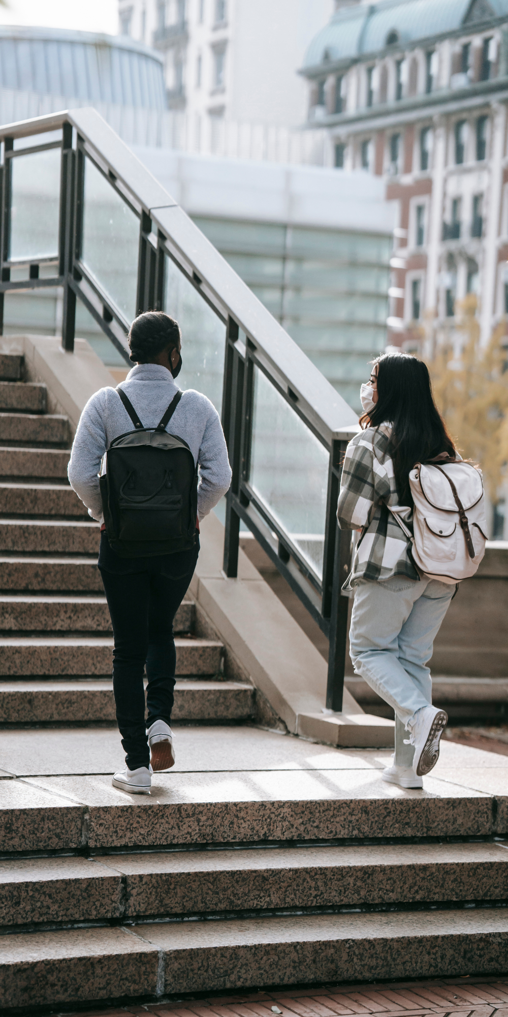 Two students walk up stairs on college campus